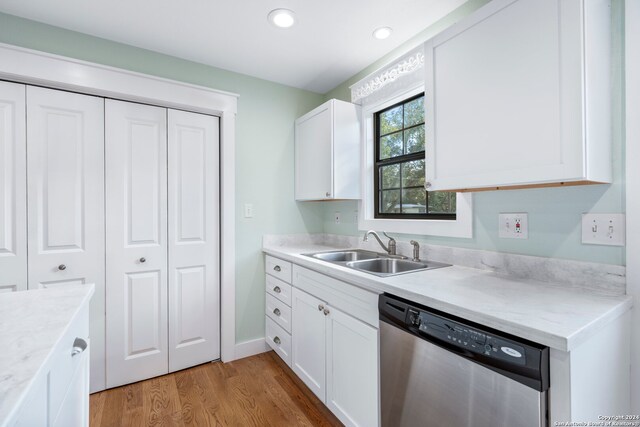 kitchen featuring dishwasher, light wood-type flooring, sink, and white cabinets