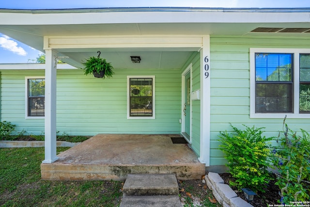 view of exterior entry featuring covered porch