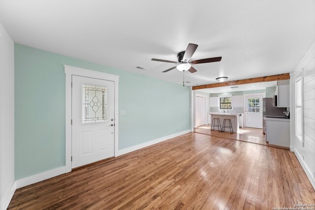 unfurnished living room with ceiling fan and light hardwood / wood-style flooring