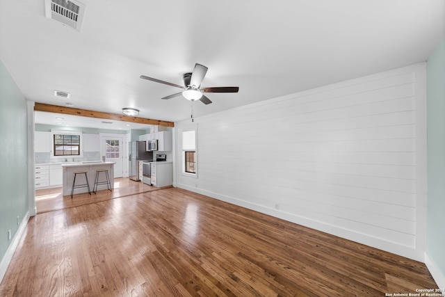 unfurnished living room featuring light hardwood / wood-style floors and ceiling fan