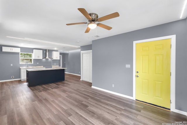 unfurnished living room featuring hardwood / wood-style floors, sink, and ceiling fan