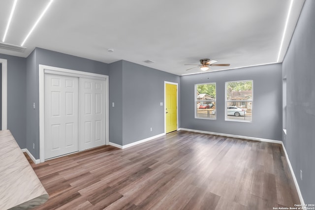 unfurnished bedroom featuring hardwood / wood-style flooring, ceiling fan, and a closet