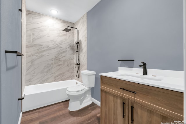 full bathroom with vanity, hardwood / wood-style flooring, toilet, and tiled shower / bath