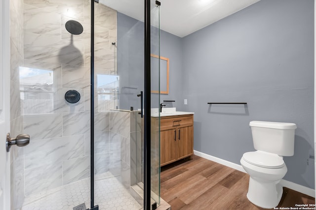 bathroom featuring an enclosed shower, vanity, hardwood / wood-style flooring, and toilet