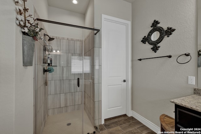 bathroom featuring vanity and a shower with door