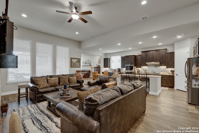 living room with light hardwood / wood-style flooring and ceiling fan