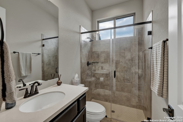 bathroom with walk in shower, vanity, and toilet