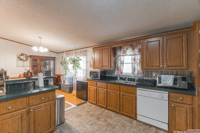 kitchen with sink, white dishwasher, a textured ceiling, backsplash, and a chandelier