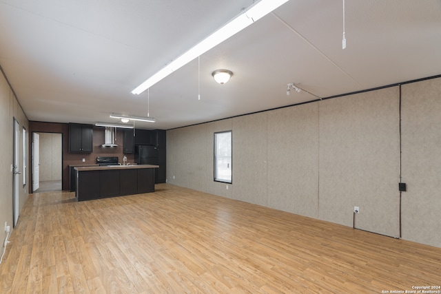 kitchen featuring light hardwood / wood-style floors, dark brown cabinetry, wall chimney exhaust hood, black range, and a kitchen island