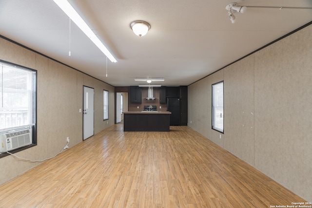 kitchen with light hardwood / wood-style floors, dark brown cabinets, cooling unit, and a center island