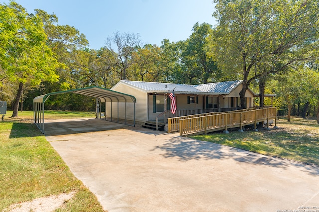 view of front facade with a front lawn, a carport, and a deck