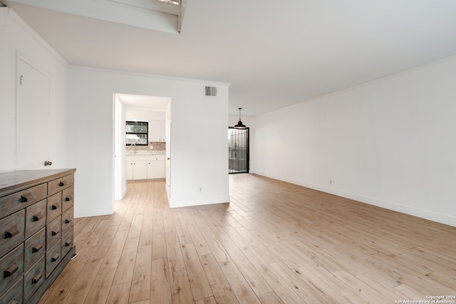 unfurnished living room with light wood-type flooring, sink, and crown molding