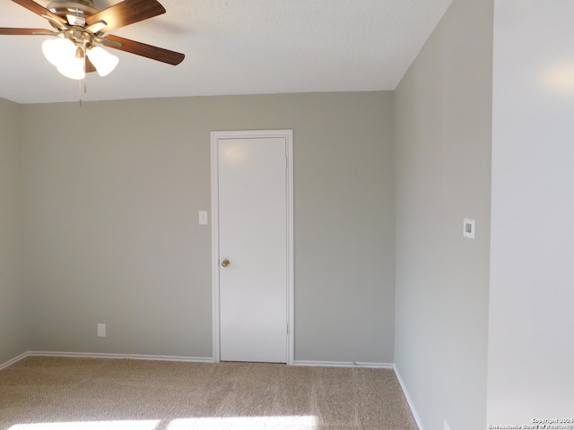 spare room featuring carpet floors and ceiling fan