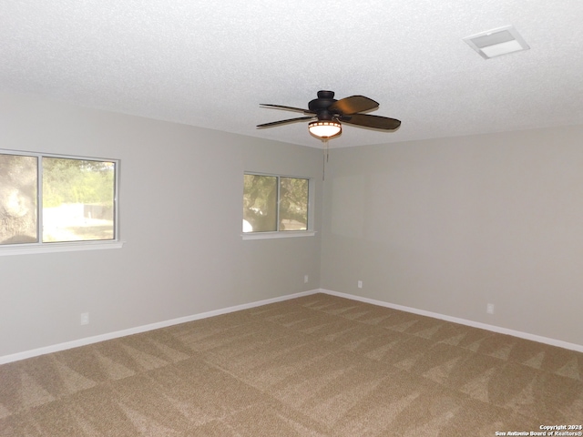 carpeted spare room with a textured ceiling and ceiling fan