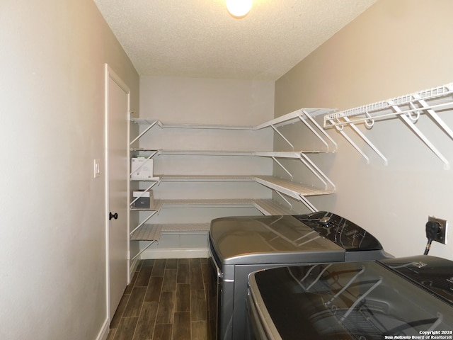 washroom featuring dark hardwood / wood-style flooring, washing machine and clothes dryer, and a textured ceiling