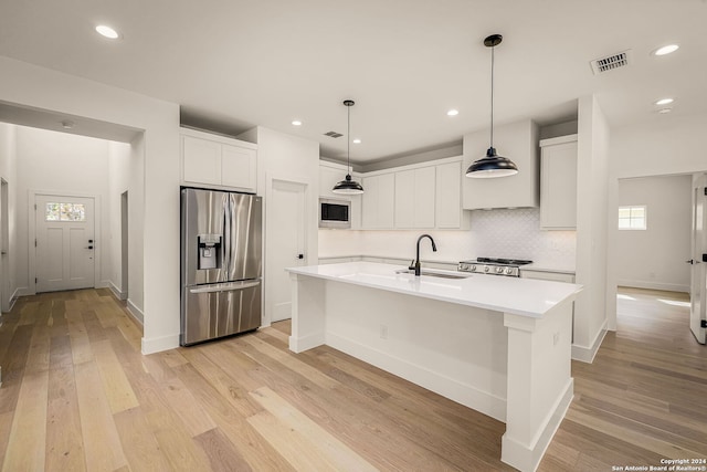 kitchen featuring white cabinets, light hardwood / wood-style flooring, sink, a kitchen island with sink, and appliances with stainless steel finishes