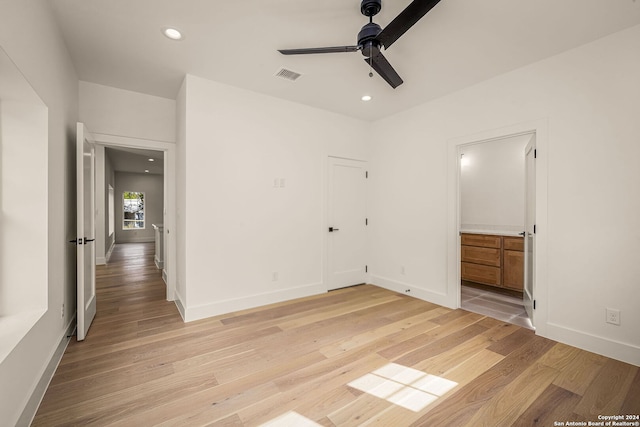 unfurnished bedroom featuring ensuite bathroom, ceiling fan, and light hardwood / wood-style flooring