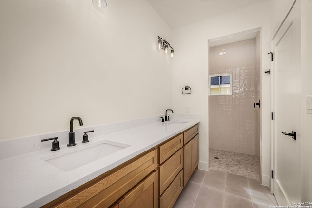 bathroom featuring vanity, tile patterned flooring, and tiled shower