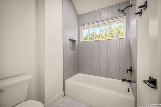 bathroom with tile patterned floors, lofted ceiling, tiled shower / bath combo, and toilet