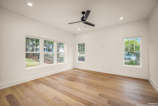 spare room featuring a wealth of natural light, ceiling fan, and light wood-type flooring