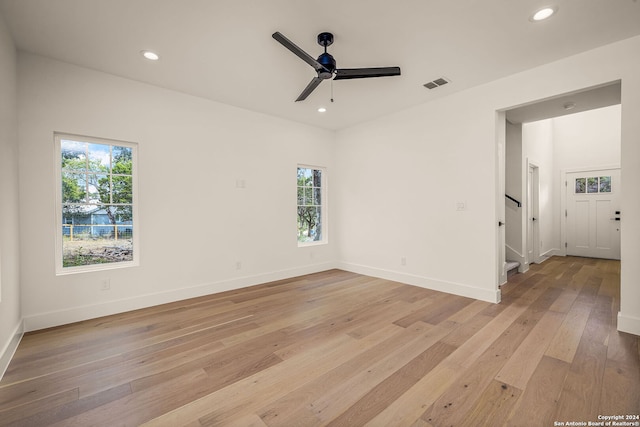 spare room featuring plenty of natural light, ceiling fan, and light hardwood / wood-style flooring