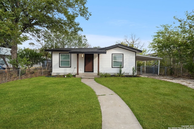 view of front of property with a front lawn and a carport