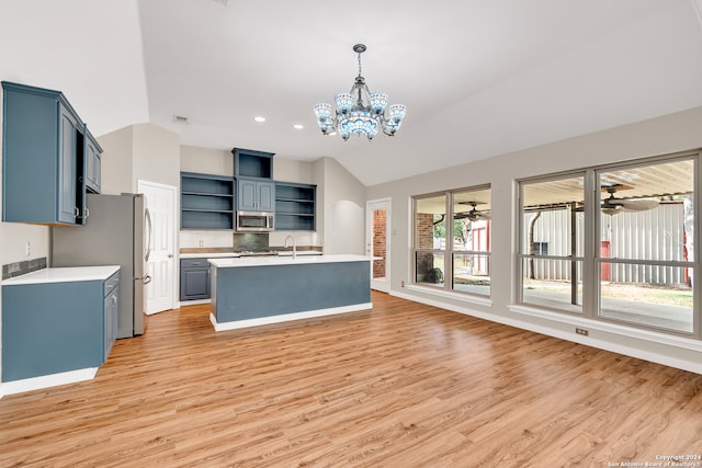 kitchen with light wood-type flooring, appliances with stainless steel finishes, and vaulted ceiling