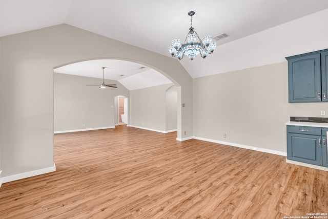 unfurnished living room featuring light wood-type flooring, ceiling fan with notable chandelier, and vaulted ceiling