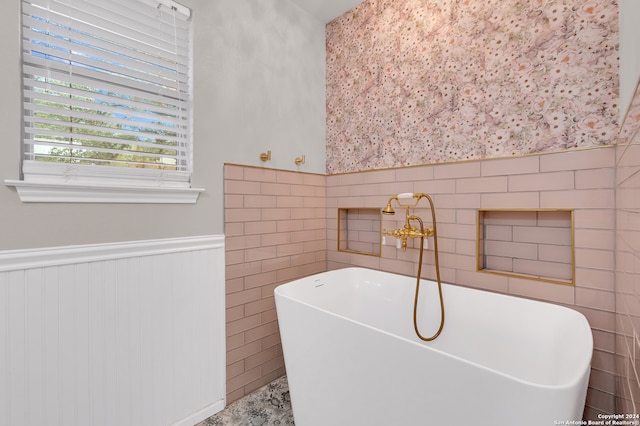 bathroom featuring tile walls and a bathing tub