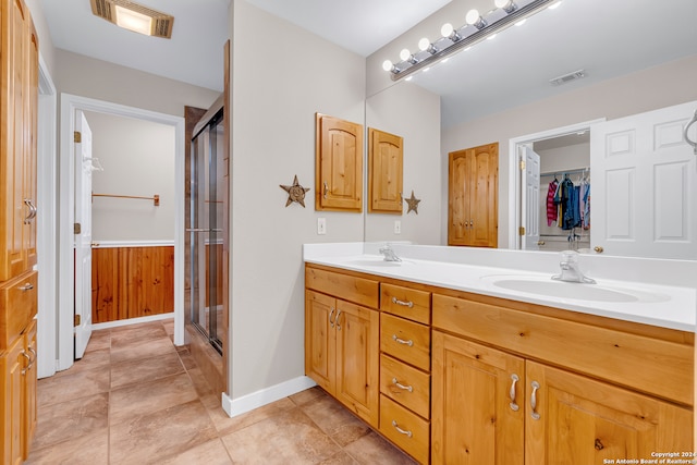 bathroom with wood walls, vanity, tile patterned floors, and a shower with shower door