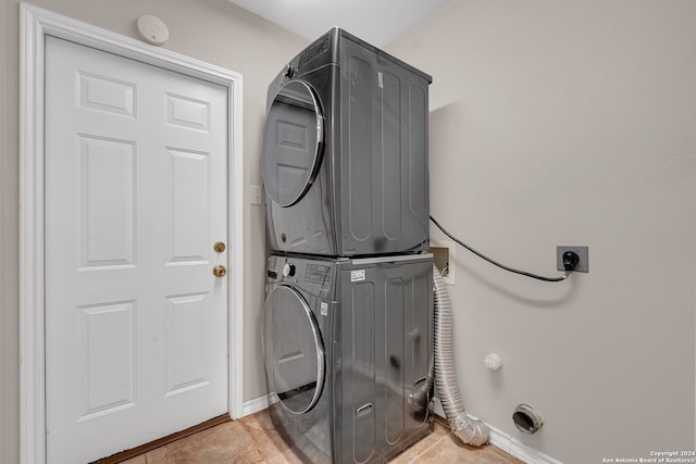 washroom with stacked washing maching and dryer and light tile patterned floors