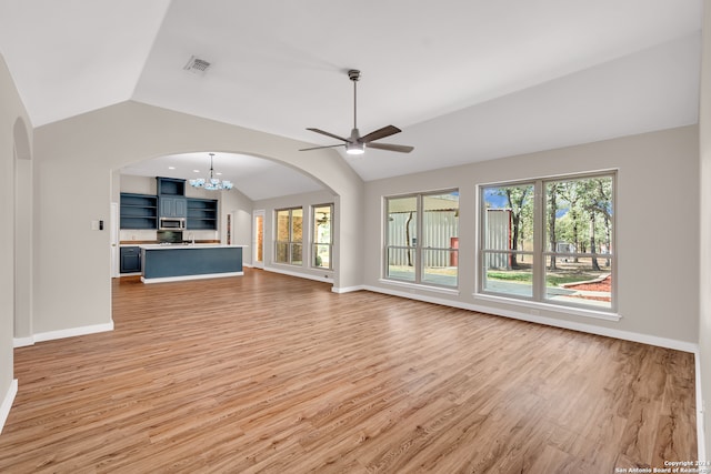 unfurnished living room featuring lofted ceiling, light hardwood / wood-style floors, and ceiling fan with notable chandelier