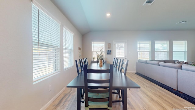 dining area with a wealth of natural light, light wood-type flooring, and vaulted ceiling