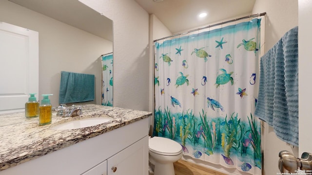 full bathroom featuring toilet, shower / tub combo, vanity, and hardwood / wood-style floors