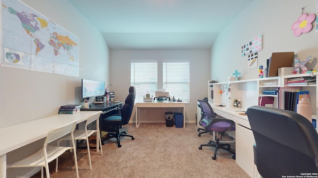 carpeted home office featuring lofted ceiling