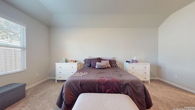 carpeted bedroom with lofted ceiling