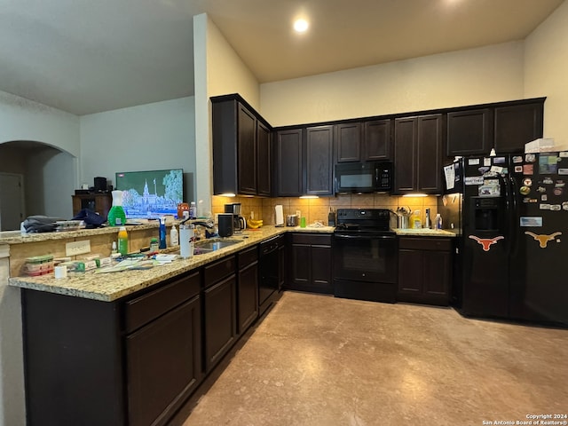 kitchen with black appliances, backsplash, light stone countertops, sink, and kitchen peninsula