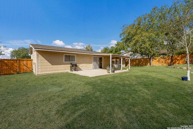 rear view of property featuring a yard and a patio area