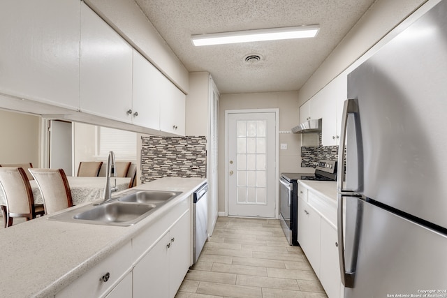 kitchen featuring stainless steel appliances, white cabinets, sink, and tasteful backsplash