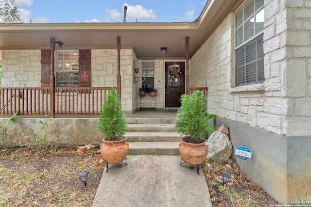 view of exterior entry with a porch