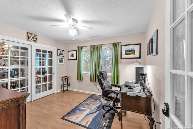 home office with ceiling fan, a textured ceiling, light hardwood / wood-style floors, and french doors