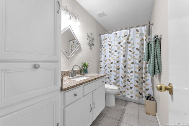 bathroom with toilet, vanity, a textured ceiling, and tile patterned flooring