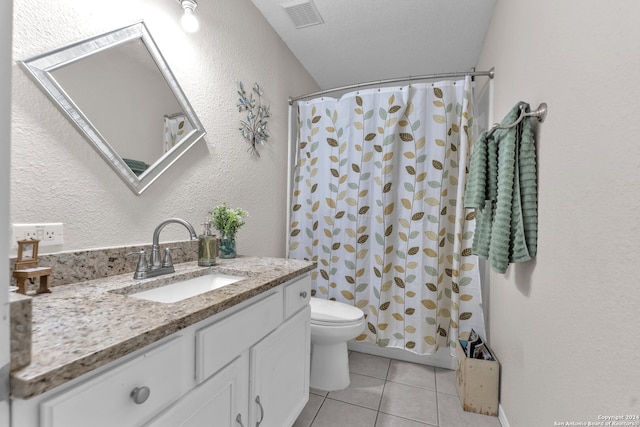 bathroom featuring vanity, tile patterned floors, toilet, and a textured ceiling