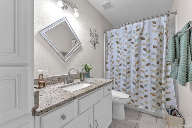 bathroom with tile patterned flooring, vanity, a textured ceiling, and toilet