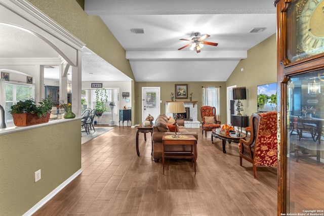 living room with a textured ceiling, lofted ceiling with beams, hardwood / wood-style flooring, and ceiling fan