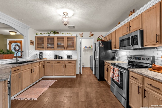 kitchen featuring stainless steel appliances, dark hardwood / wood-style floors, sink, and light stone counters