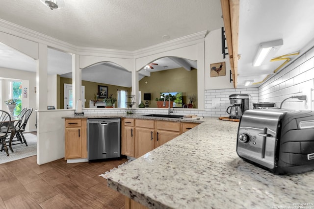 kitchen featuring a textured ceiling, light stone countertops, decorative backsplash, sink, and stainless steel dishwasher