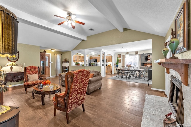 living room with a textured ceiling, hardwood / wood-style floors, lofted ceiling with beams, and ceiling fan