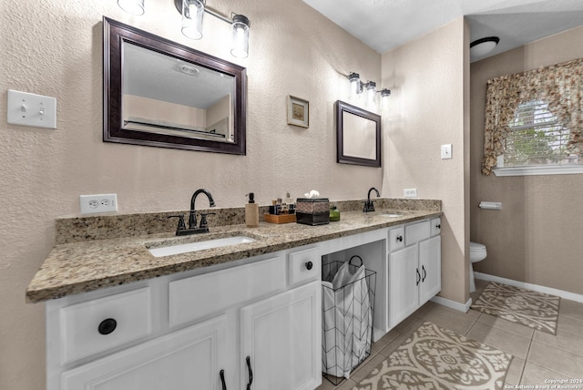 bathroom featuring toilet, vanity, and tile patterned floors