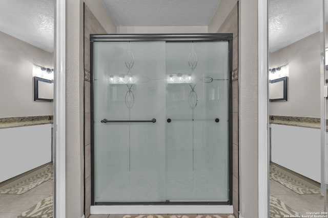 bathroom featuring a textured ceiling and tile patterned floors